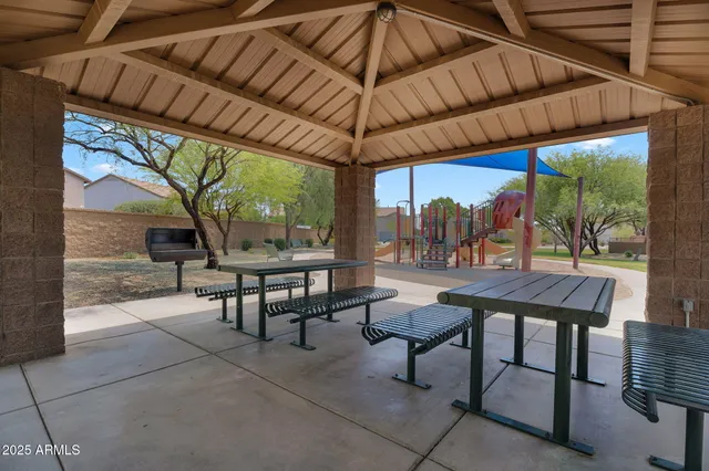 a patio with glass top table and chairs
