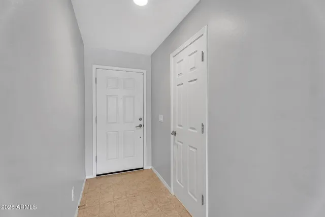 a view of a hallway with wooden floor and closet