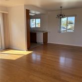 an empty room with wooden floor windows and entrance