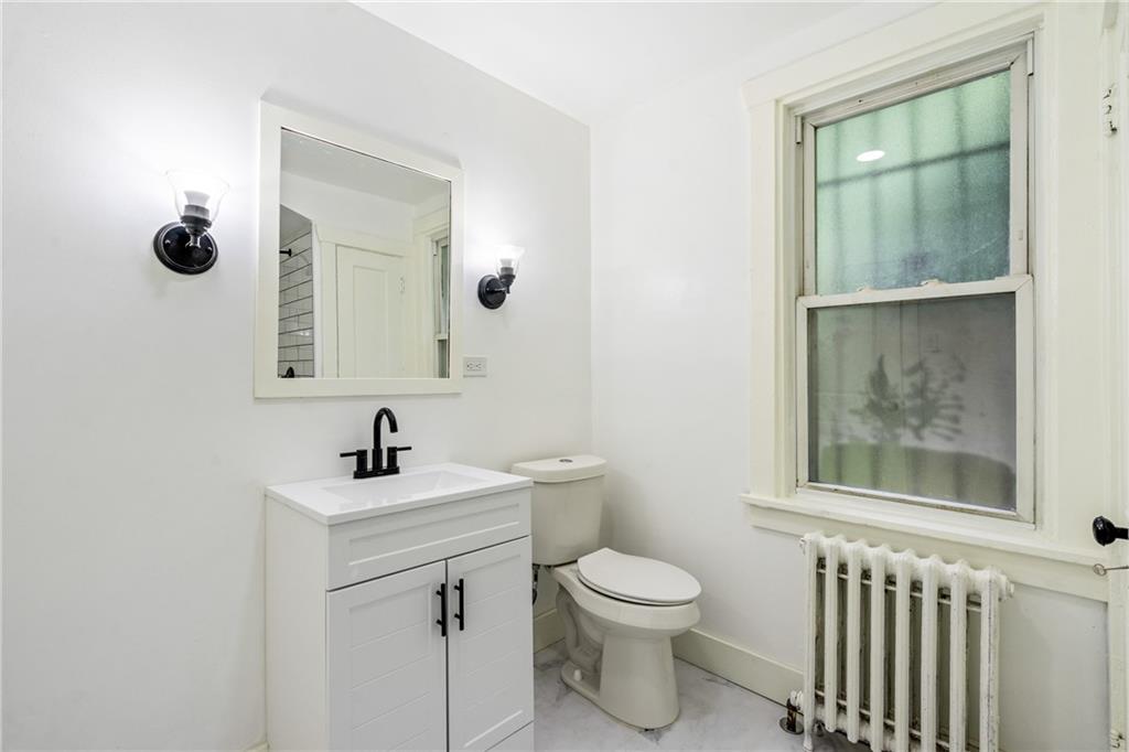 8619 Westwood Road Pittsburgh, PA 15235 - Photo 20 of 26 a bathroom with a toilet a sink and mirror