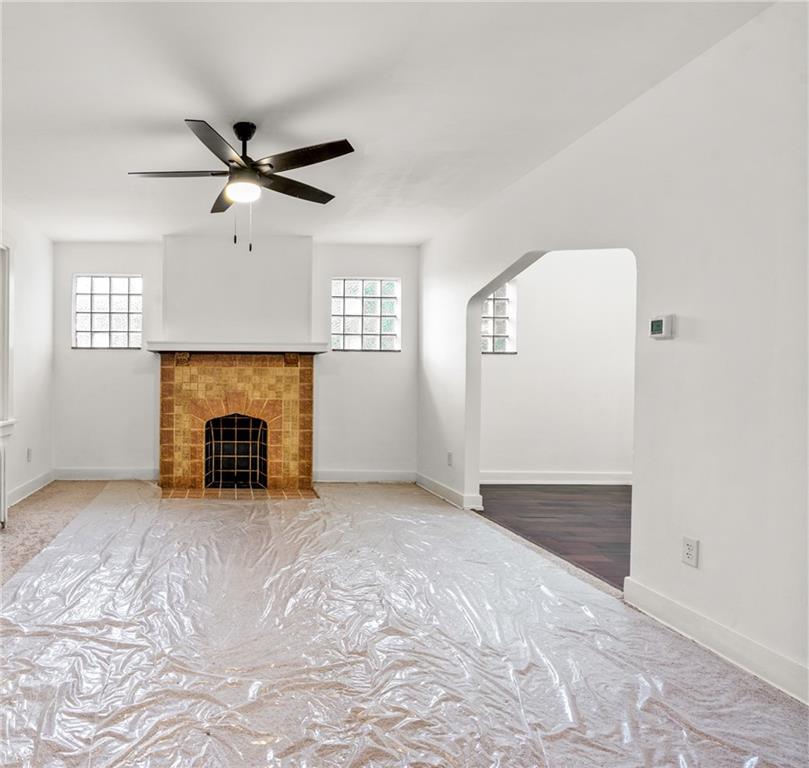 8619 Westwood Road Pittsburgh, PA 15235 - Photo 6 of 26 an empty room with windows fireplace and a ceiling fan