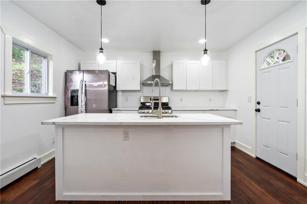 8619 Westwood Road Pittsburgh, PA 15235 - Photo 9 of 26 a kitchen with stainless steel appliances kitchen island a sink a refrigerator and windows