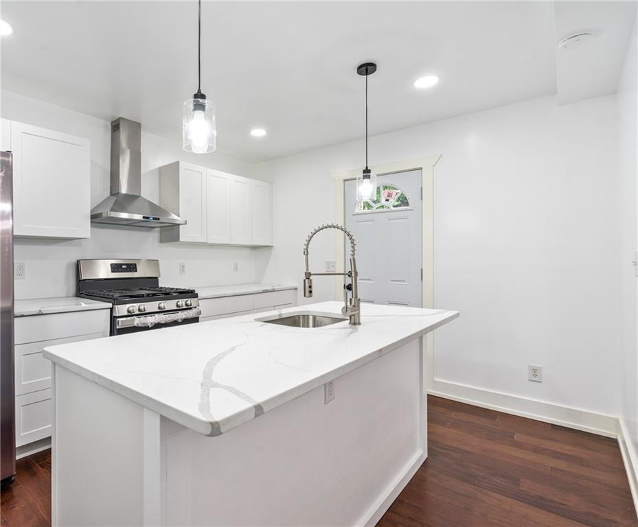 8619 Westwood Road Pittsburgh, PA 15235 - Photo 10 of 26 a kitchen with stainless steel appliances a sink a stove a refrigerator and wooden floor