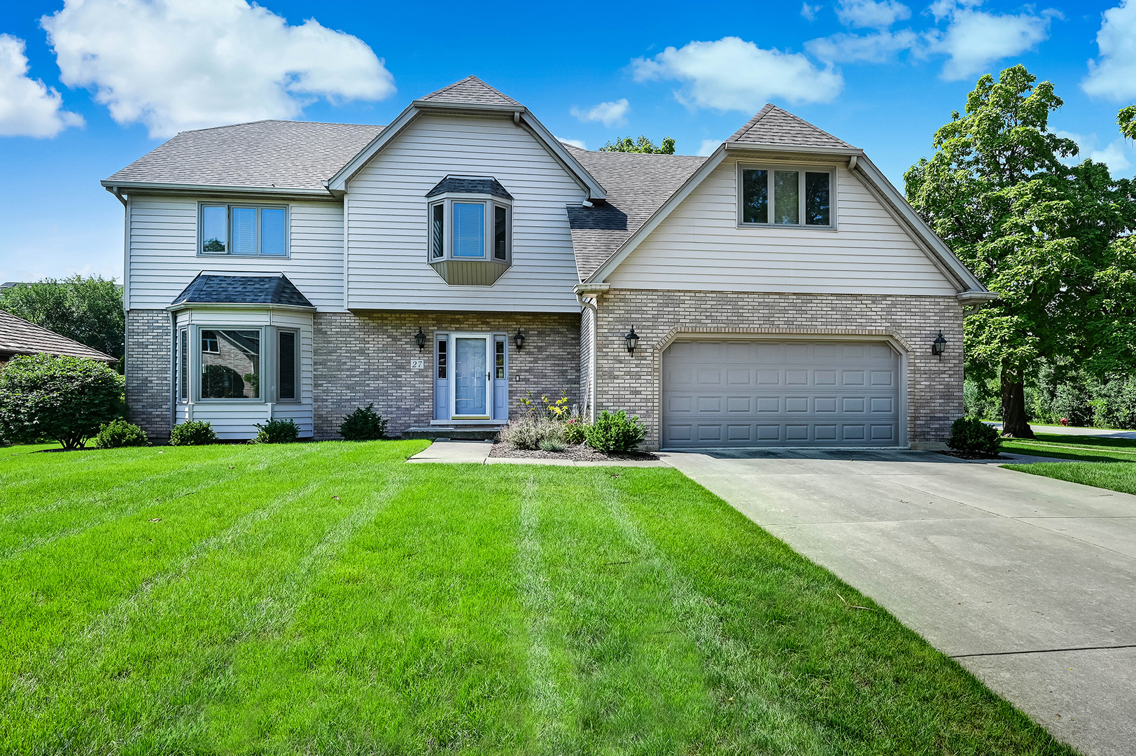 a front view of a house with a yard and garage