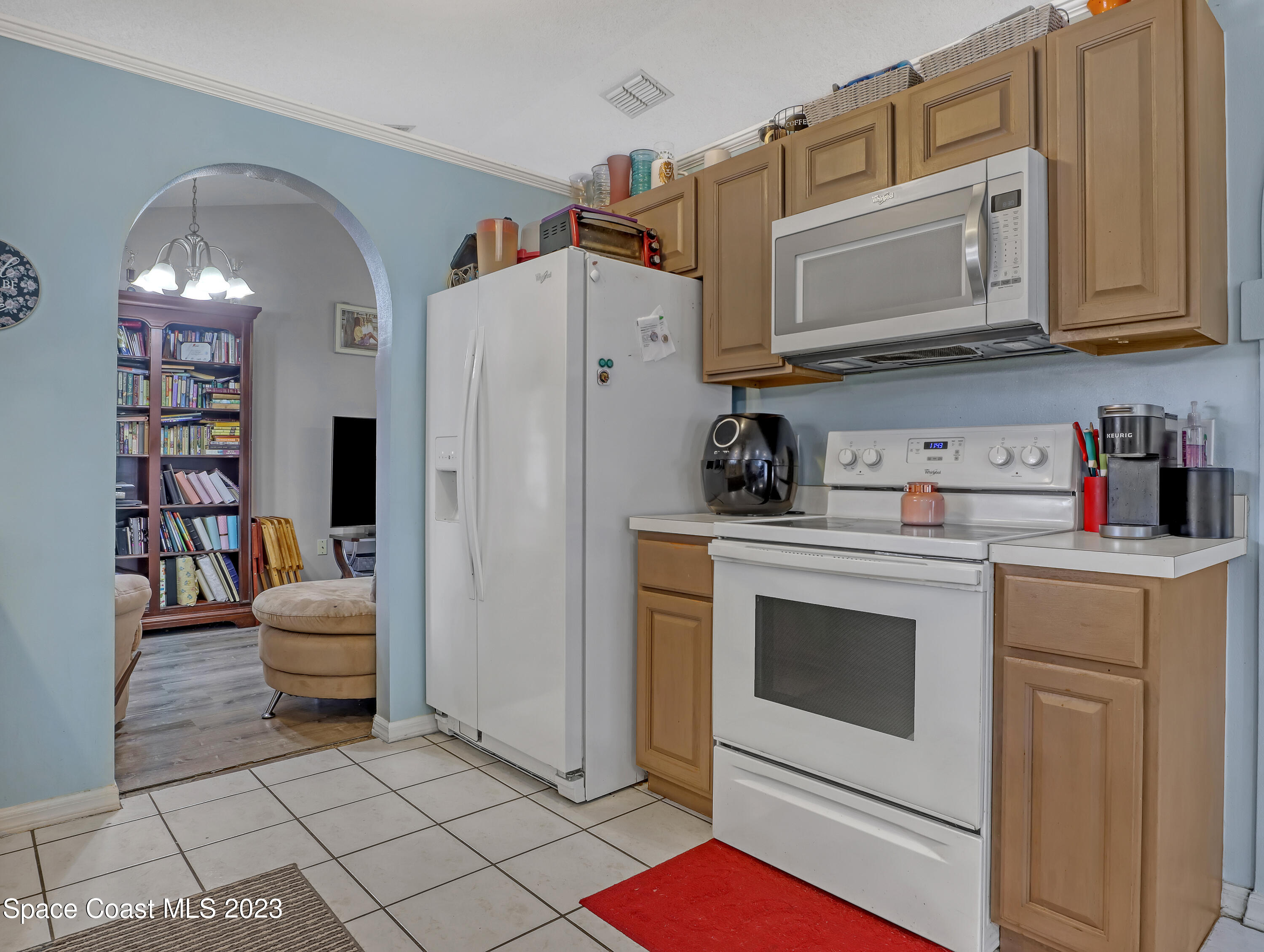 2305 Shady Oak Road Melbourne, FL 32935 - Photo 13 of 38 a kitchen with stainless steel appliances white cabinets and white appliances