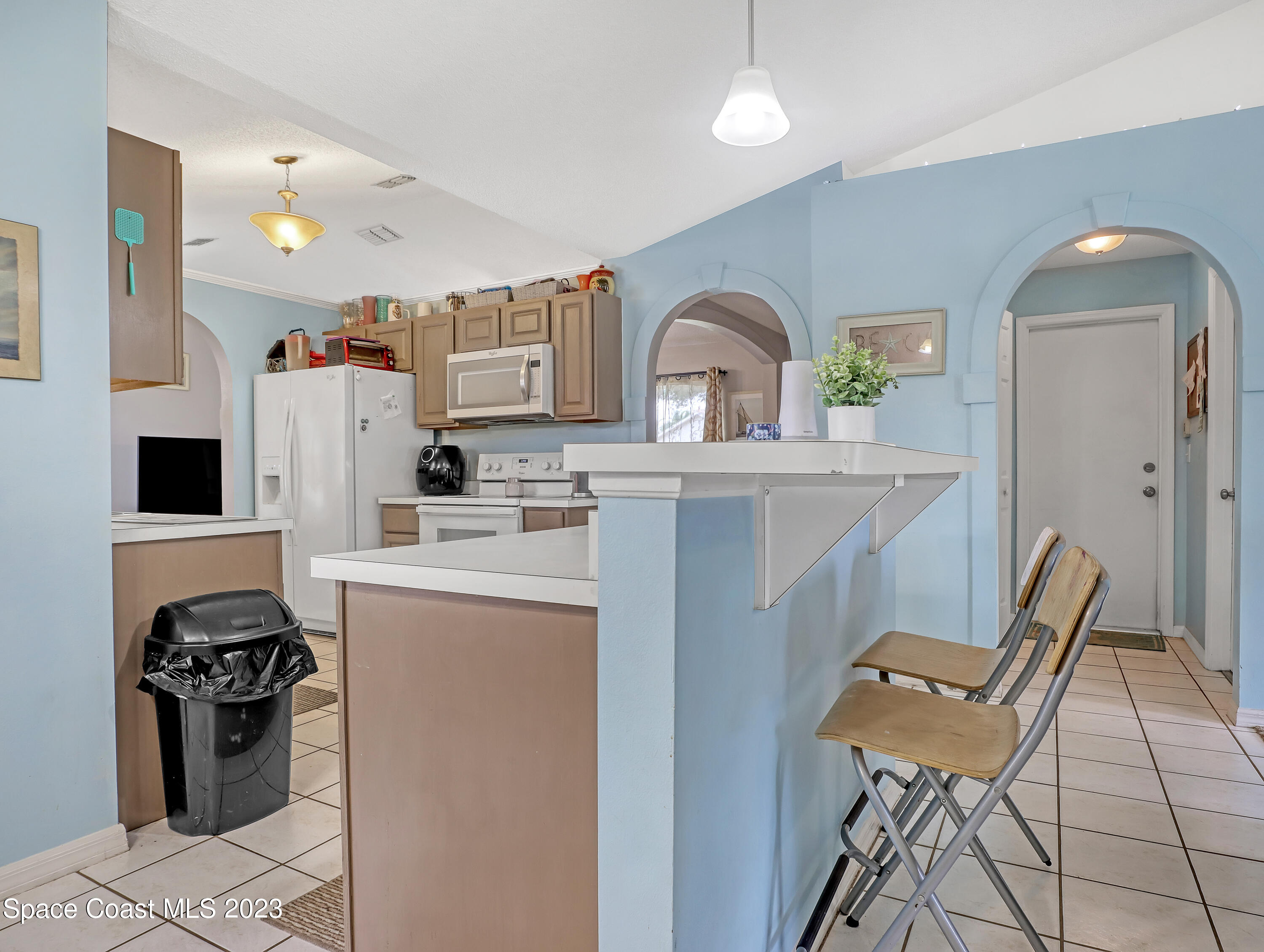 2305 Shady Oak Road Melbourne, FL 32935 - Photo 15 of 38 a kitchen with stainless steel appliances kitchen island a stove a sink a refrigerator cabinets and a dining table