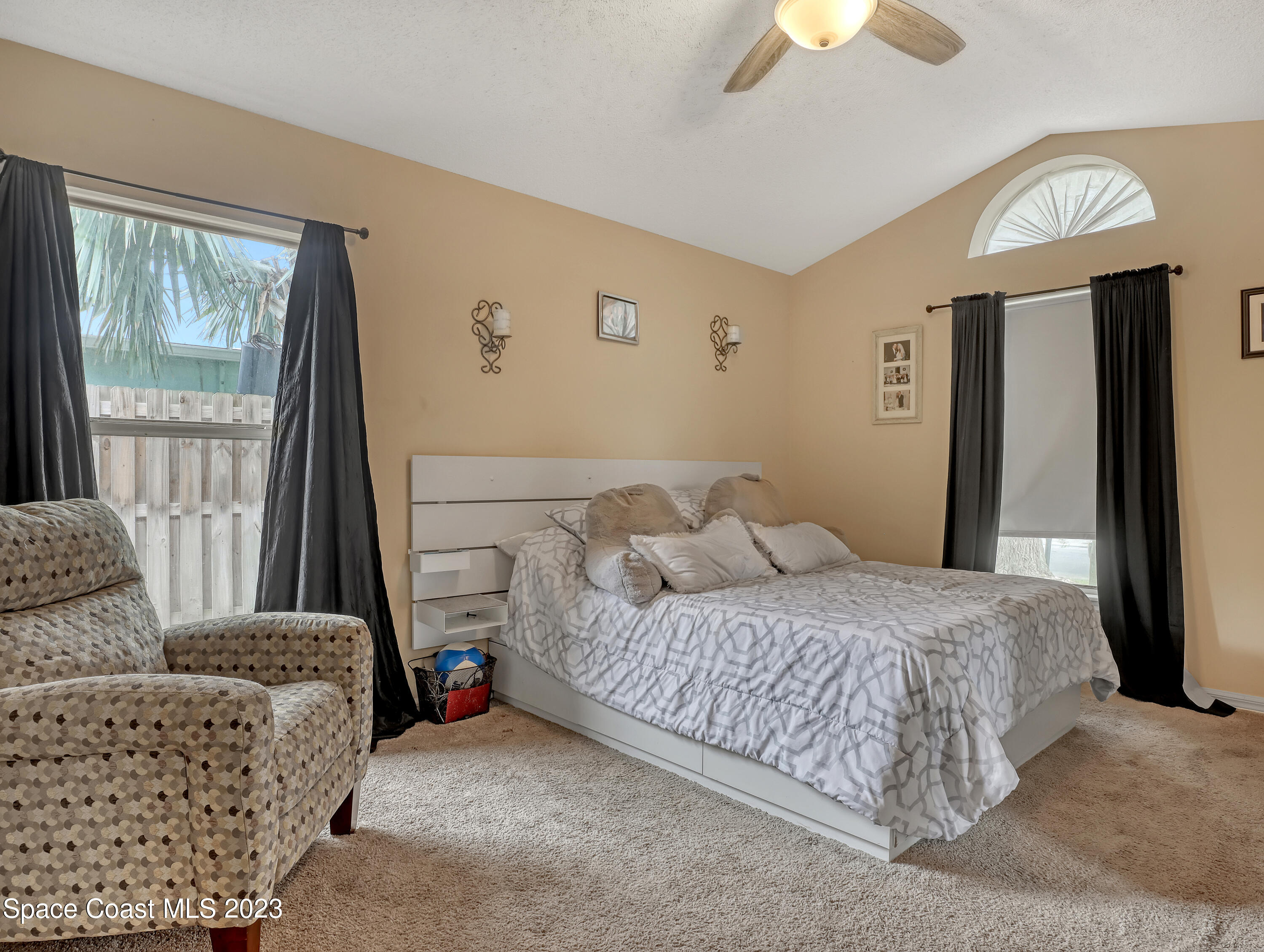 2305 Shady Oak Road Melbourne, FL 32935 - Photo 21 of 38 a bedroom with a bed and a chandelier