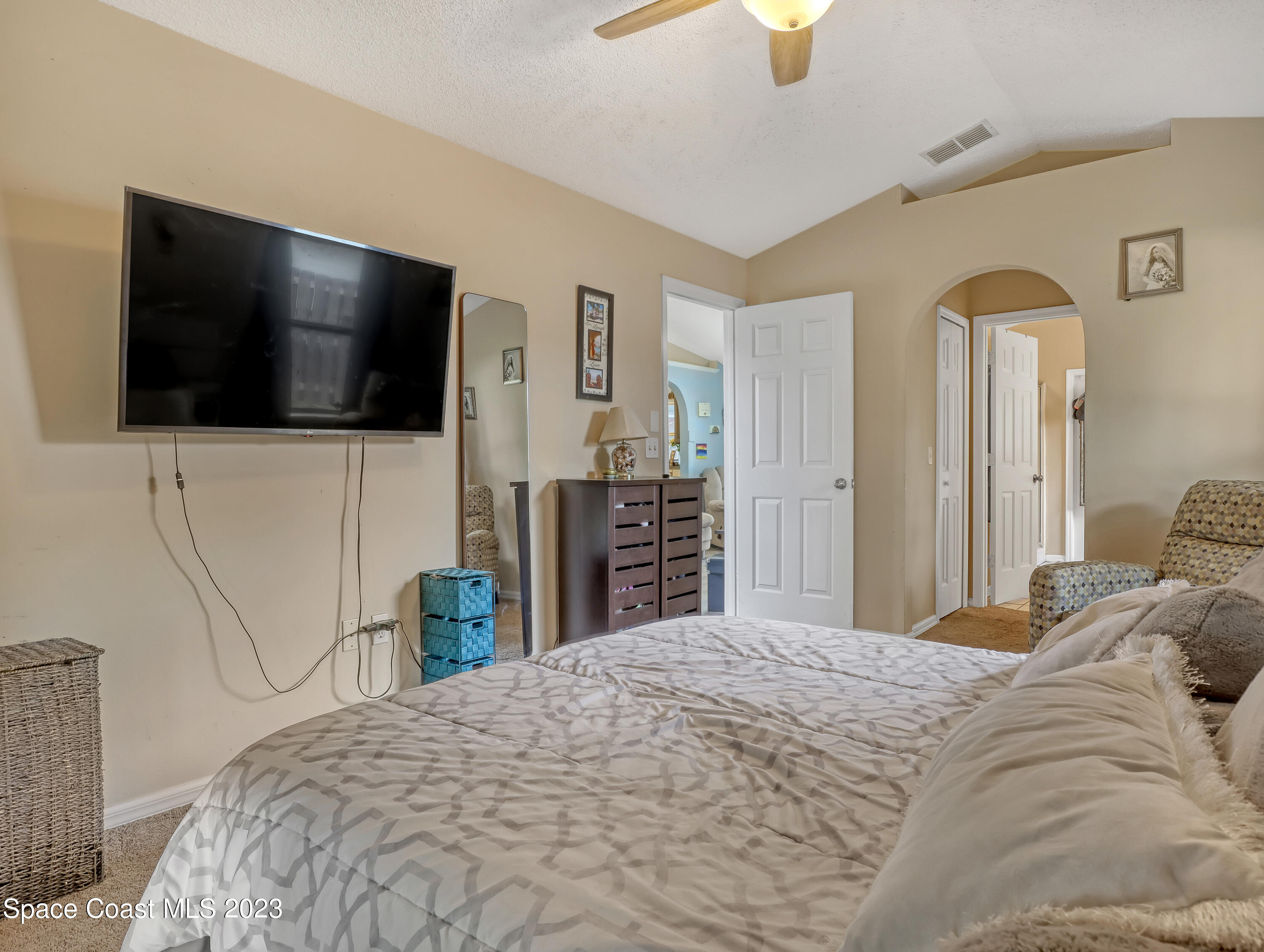 2305 Shady Oak Road Melbourne, FL 32935 - Photo 22 of 38 a bedroom with a bed and a flat screen tv
