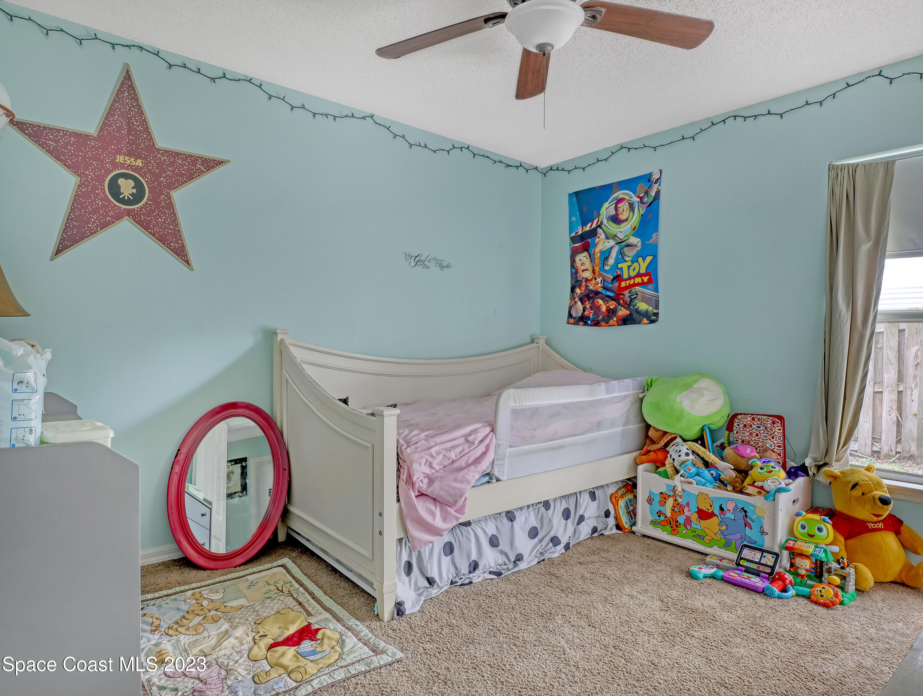 2305 Shady Oak Road Melbourne, FL 32935 - Photo 29 of 38 a bedroom with a bed and a chandelier