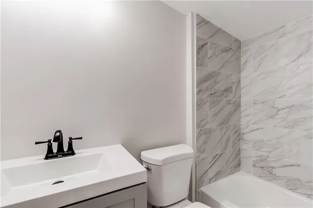 a bathroom with a sink a toilet and mirror