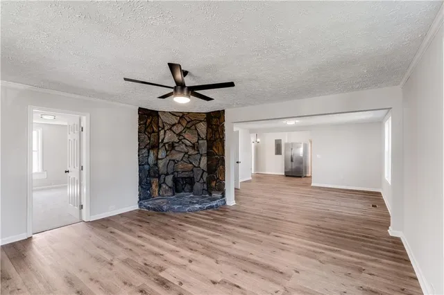 a view of a room with wooden floor and ceiling fan