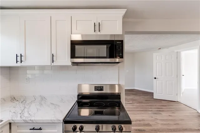 a kitchen with stainless steel appliances a stove a microwave and cabinets