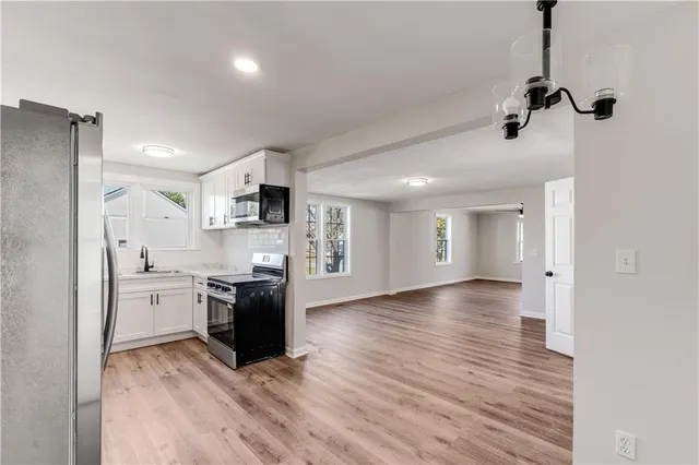 a large kitchen with cabinets wooden floor and stainless steel appliances
