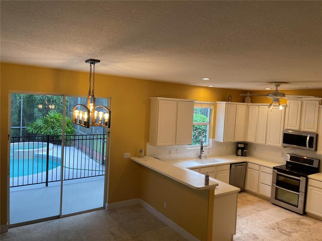 759 Fordingbridge Way Osprey, FL 34229 - Photo 31 of 51 a kitchen with stainless steel appliances granite countertop a sink a stove and a wooden floors
