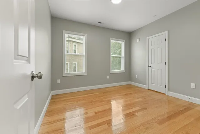 a view of an empty room with window and closet area