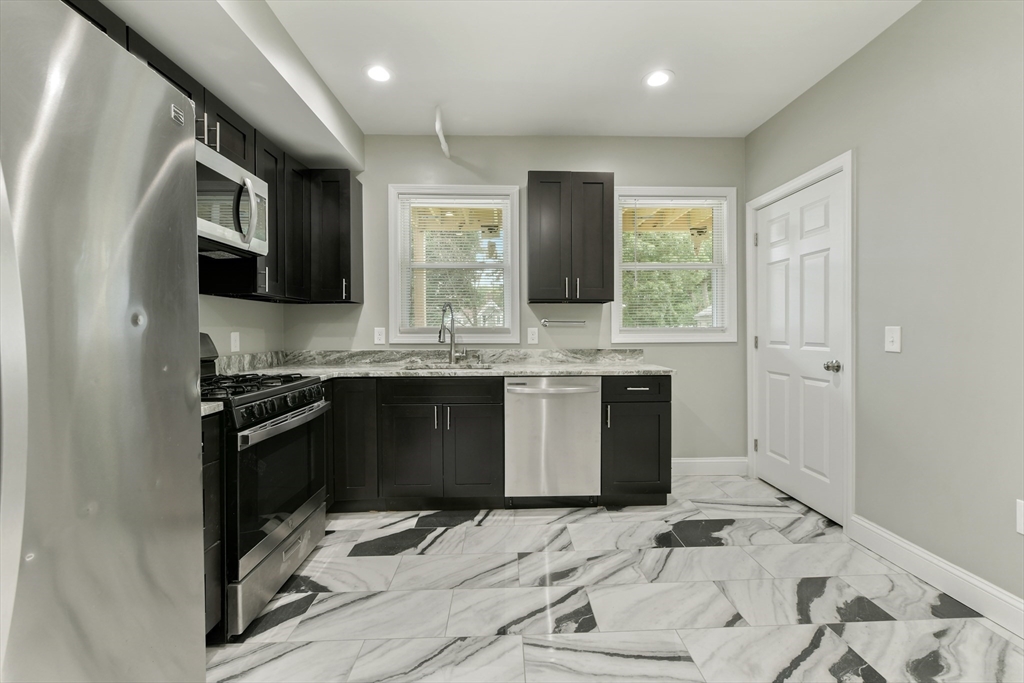 34 Fessenden Street, Unit 2 Boston, MA 02126 - Photo 15 of 21 a kitchen with stainless steel appliances kitchen island granite countertop a sink stove and refrigerator