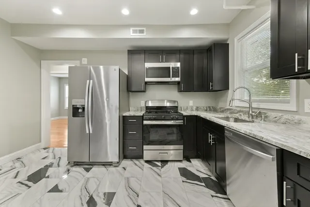 a kitchen with stainless steel appliances granite countertop a refrigerator and a sink