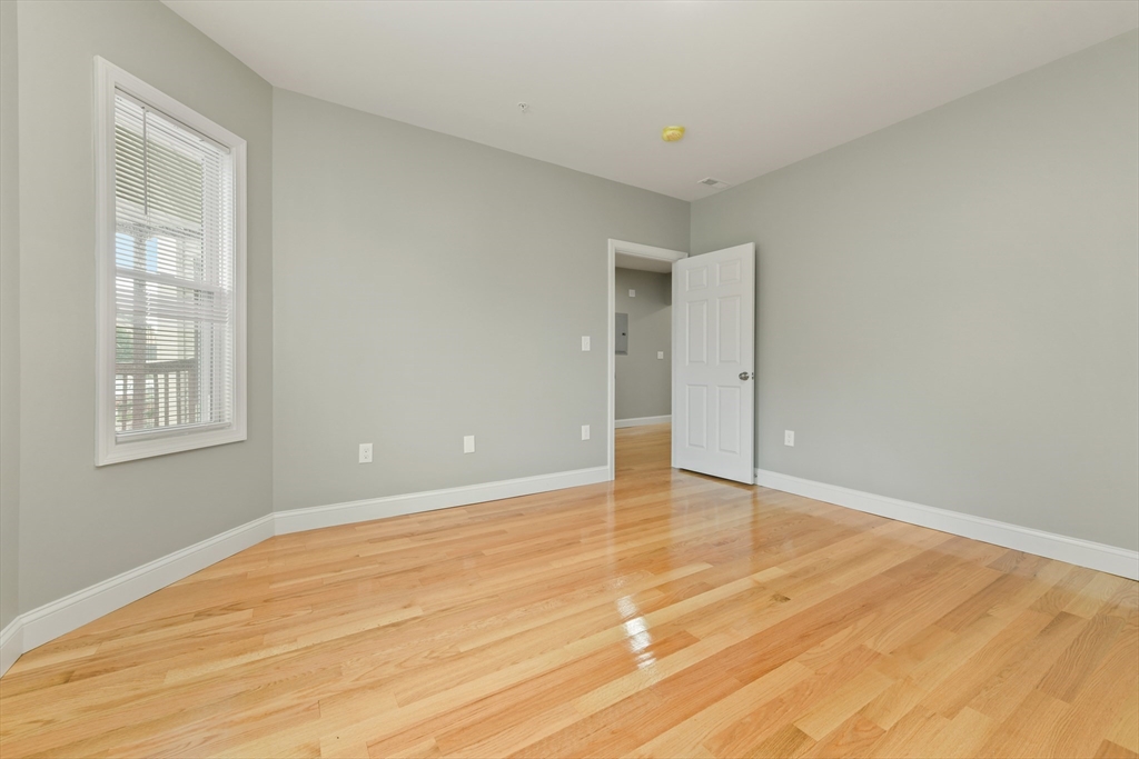 34 Fessenden Street, Unit 2 Boston, MA 02126 - Photo 4 of 21 a view of an empty room with wooden floor and a window