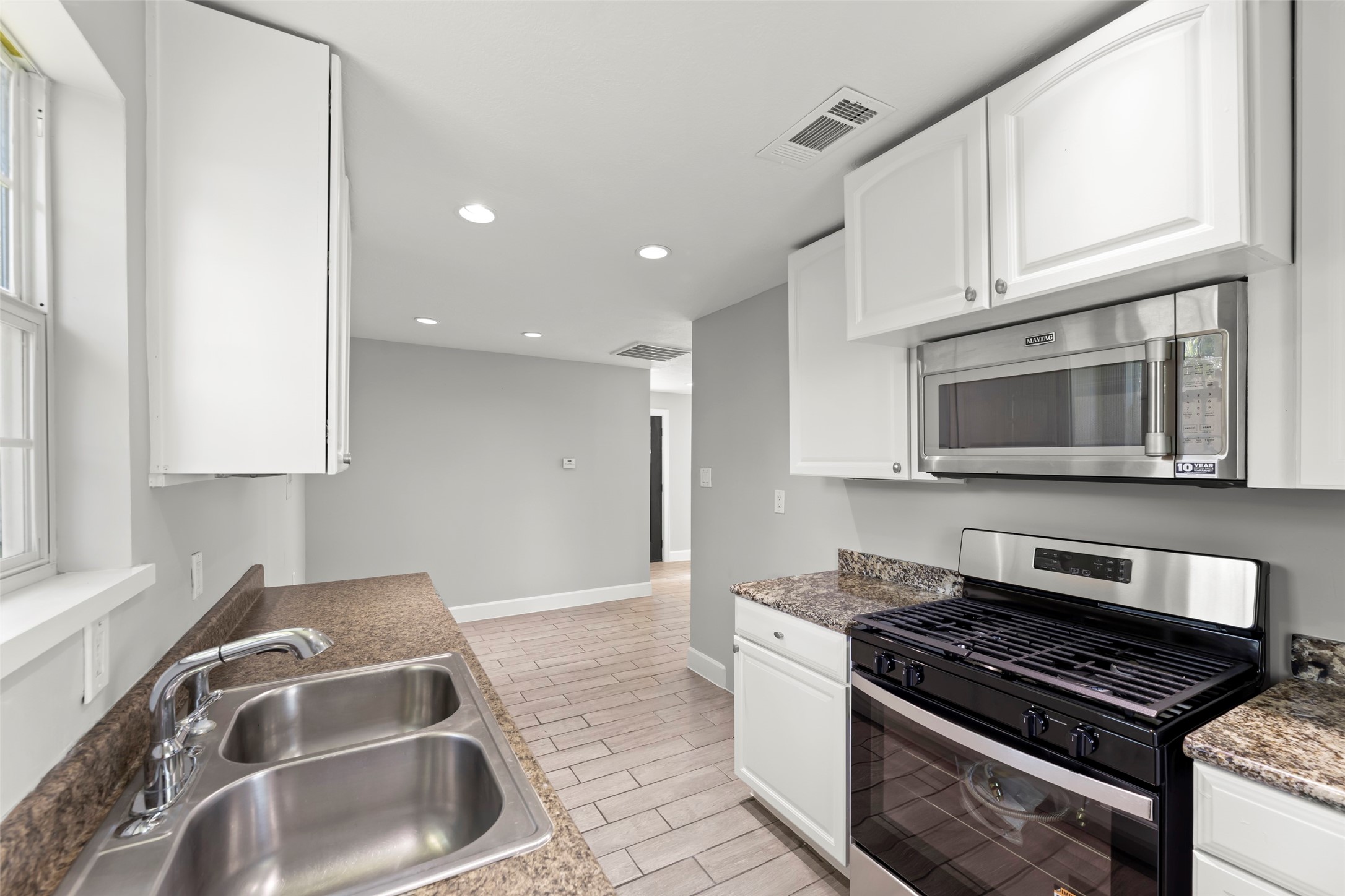 729 Caperton Street Houston, TX 77022 - Photo 32 of 42 a kitchen with granite countertop a stove and a sink