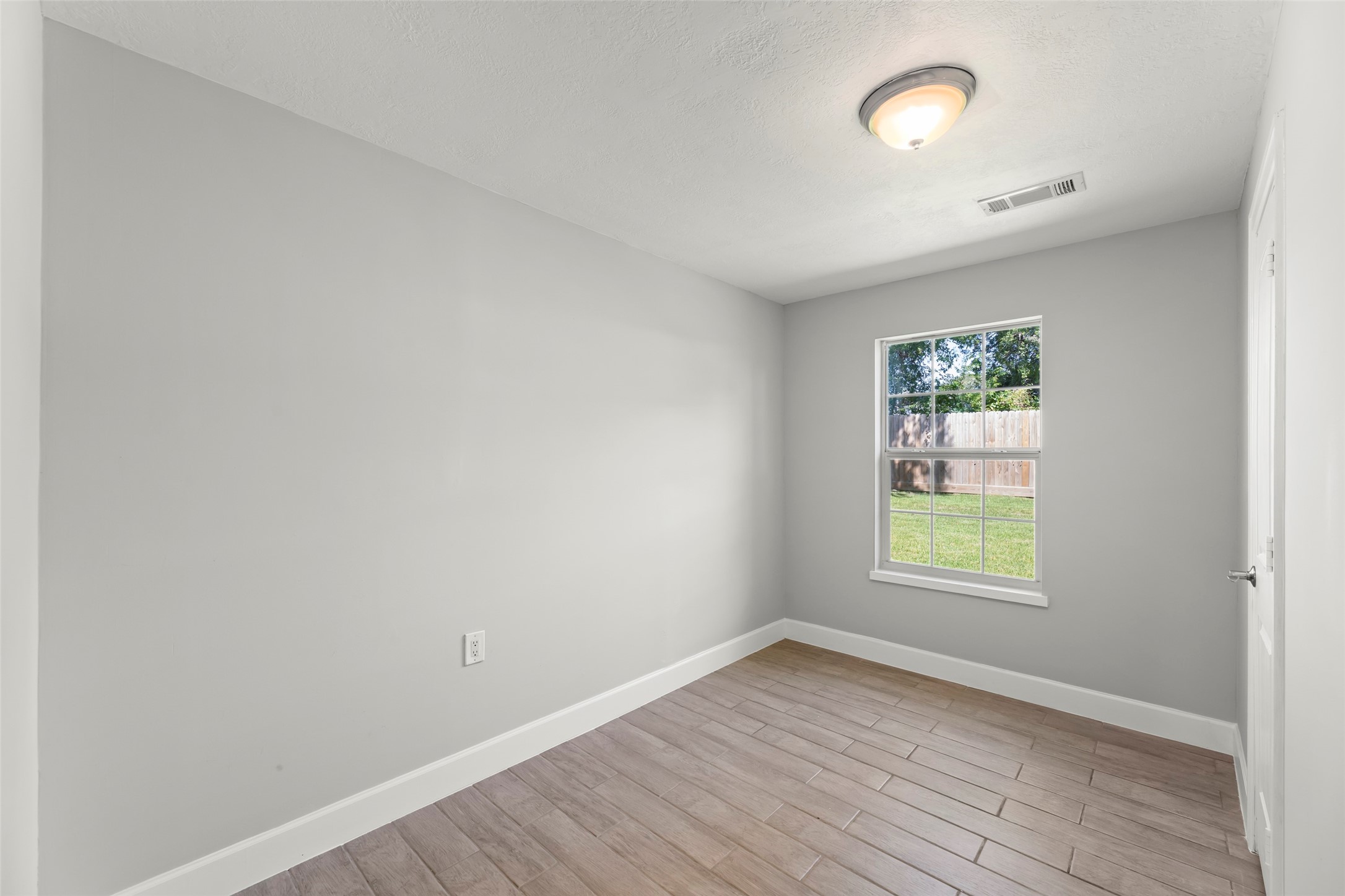729 Caperton Street Houston, TX 77022 - Photo 35 of 42 an empty room with wooden floor and windows