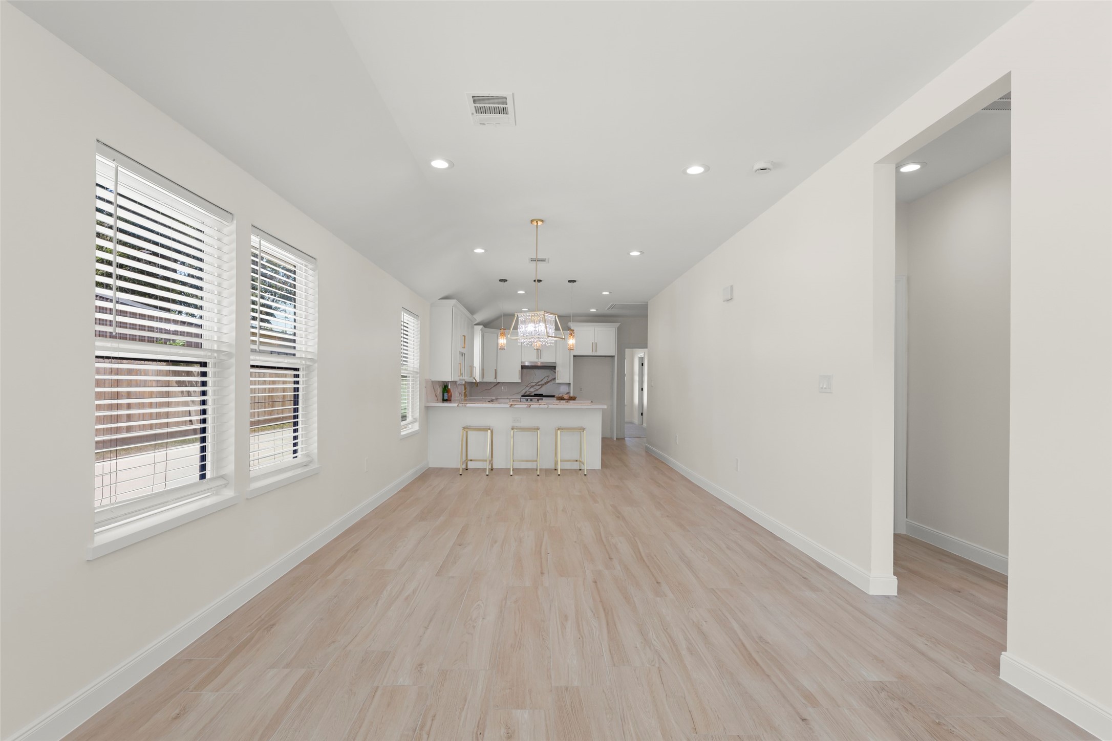 729 Caperton Street Houston, TX 77022 - Photo 7 of 42 a view of a kitchen with kitchen island a sink wooden floor and a refrigerator