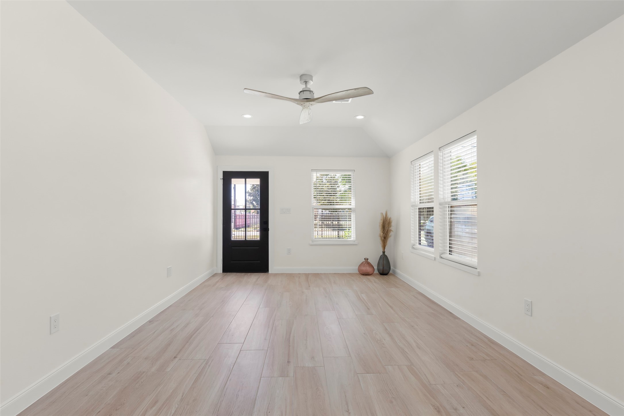 729 Caperton Street Houston, TX 77022 - Photo 8 of 42 an empty room with wooden floor chandelier fan and windows