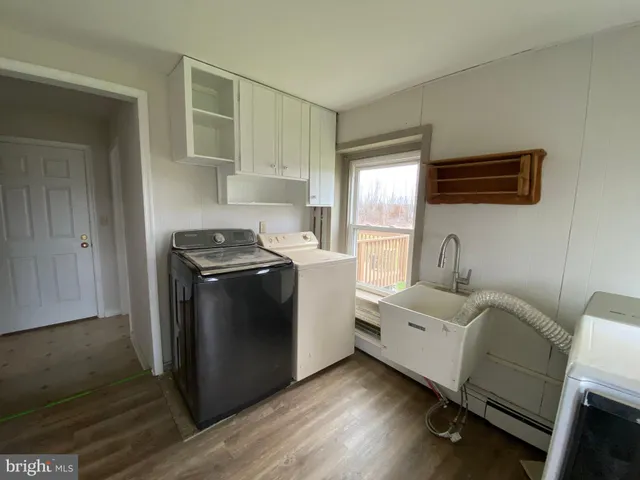 a view of a kitchen with wooden floor and electronic appliances