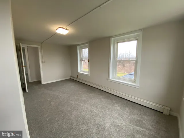 a view of a hallway with wooden floor and a chandelier