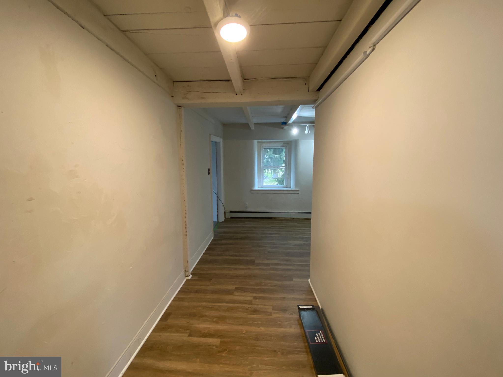2063 Hill Road, Unit B Perkiomenville, PA 18074 - Photo 17 of 27 a view of a hallway with wooden floor and a chandelier