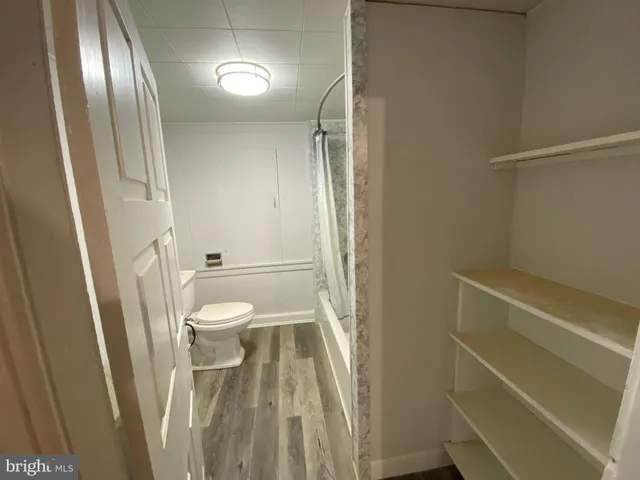a white toilet sitting next to a bath tub