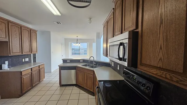 a kitchen with granite countertop a sink stove and cabinets