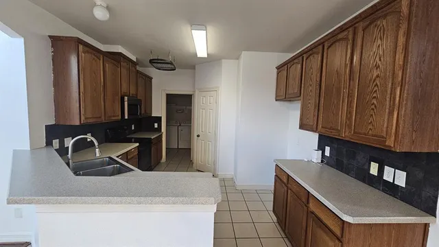 a kitchen with stainless steel appliances granite countertop a sink a stove and a refrigerator