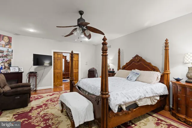 a bedroom with a bed a couch and a flat tv screen