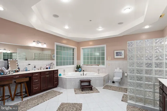 a bathroom with a double vanity sink large mirror and a bathtub