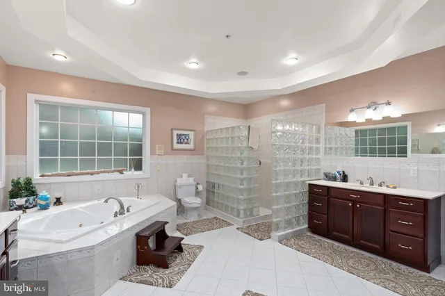 a bathroom with a tub sink toilet and window