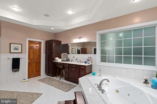 a large bathroom with a tub a sink and a large mirror
