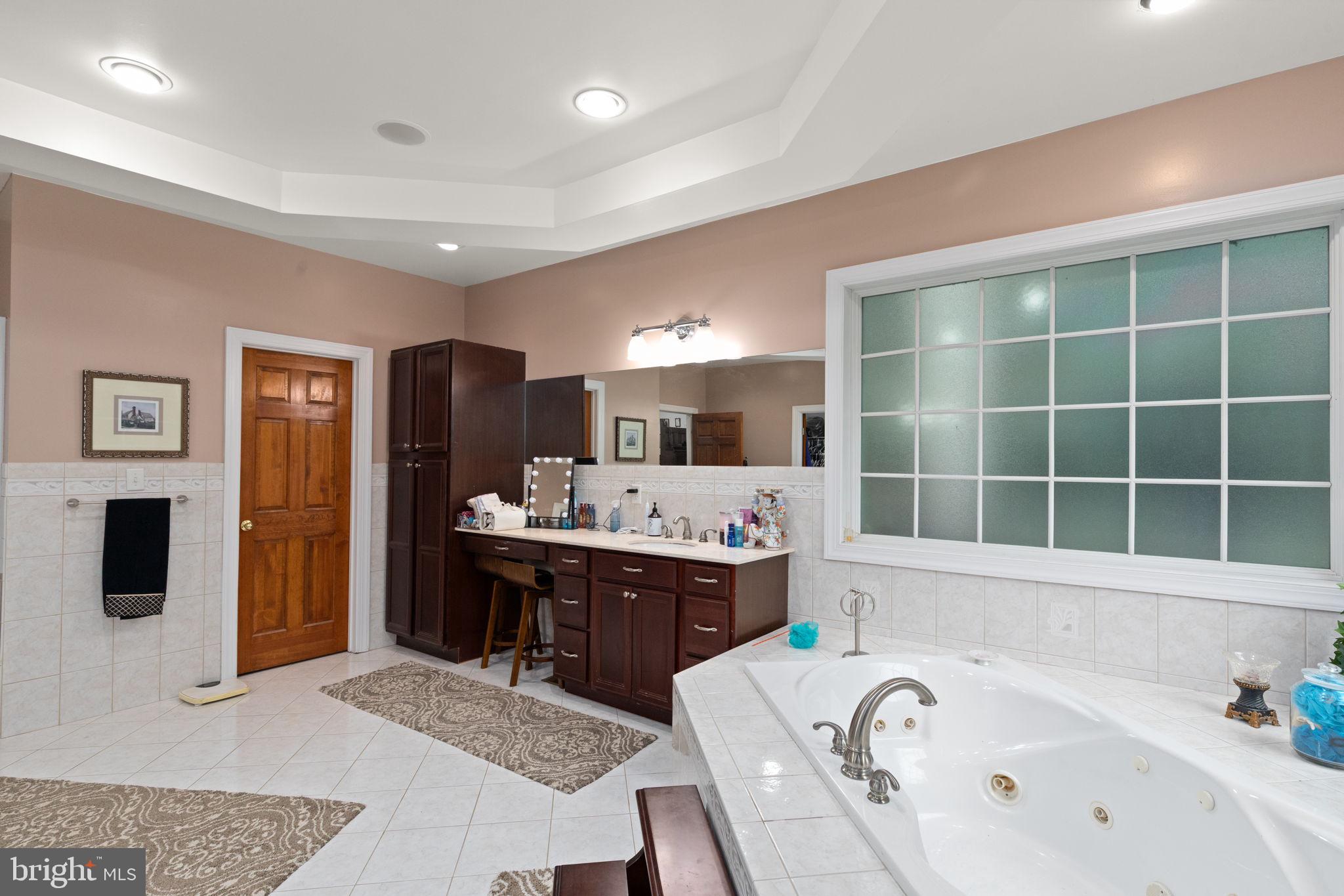 5530 Jim Pickett Road Sykesville, MD 21784 - Photo 23 of 49 a large bathroom with a tub a sink and a large mirror