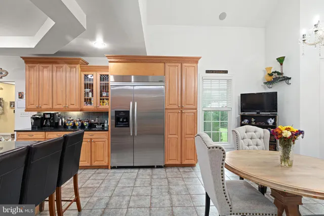 a kitchen with stainless steel appliances granite countertop a refrigerator a stove a microwave a dining table and chairs