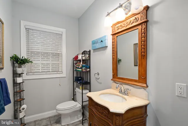 a bathroom with a sink vanity mirror and toilet