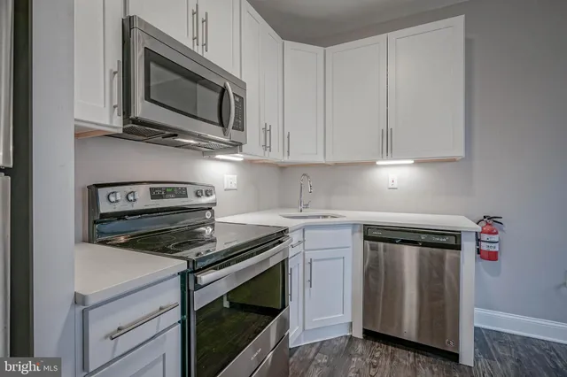a kitchen with microwave cabinets and stove top oven