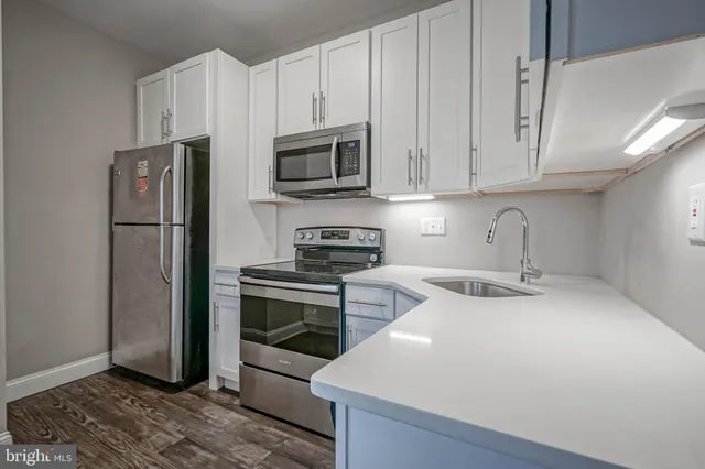 a kitchen with stainless steel appliances granite countertop a refrigerator sink and stove