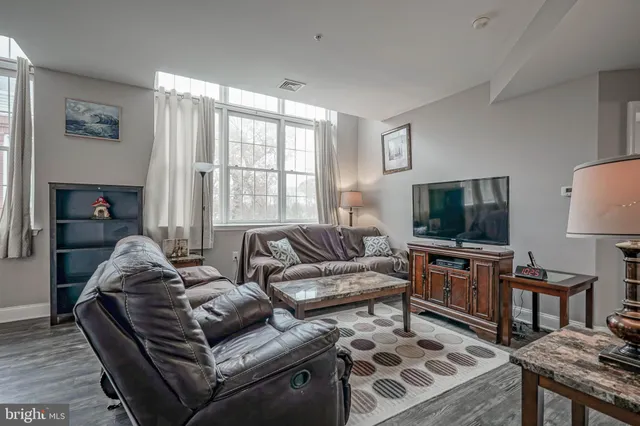 a living room with furniture a flat screen tv and a large window