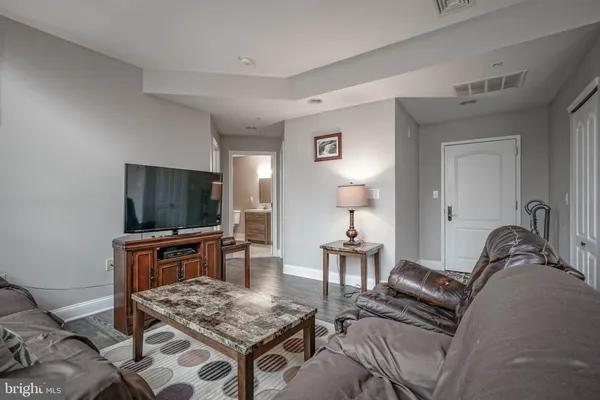 a living room with furniture a flat screen tv and kitchen island
