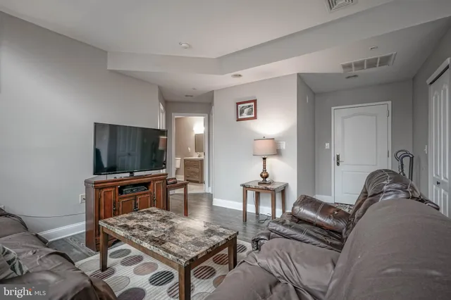 a living room with furniture a flat screen tv and kitchen island