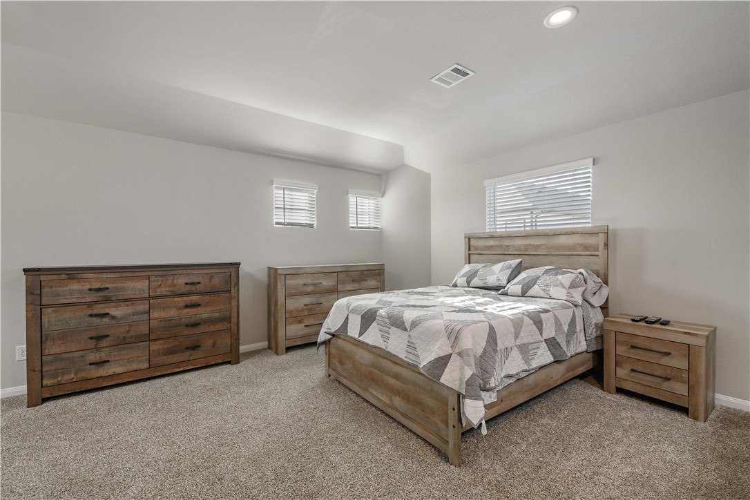 4705 Milagro Loop Bryan, TX 77807 - Photo 18 of 28 a bedroom with a bed and a dresser