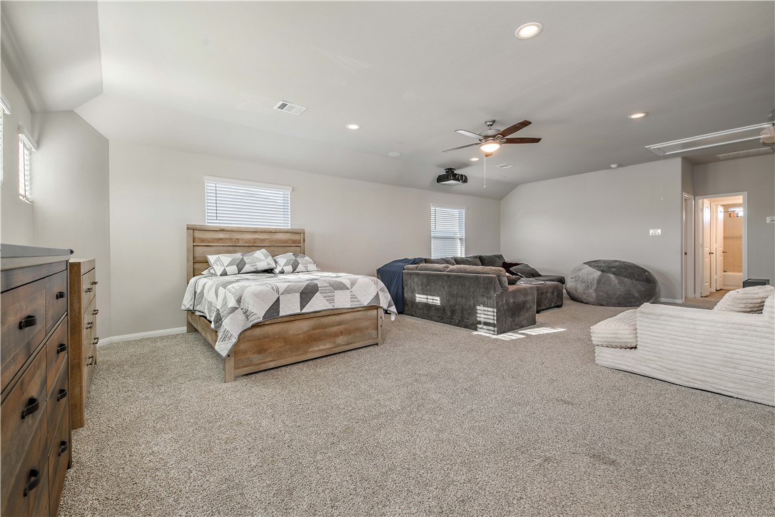 4705 Milagro Loop Bryan, TX 77807 - Photo 20 of 28 a spacious bedroom with a bed and ceiling fan