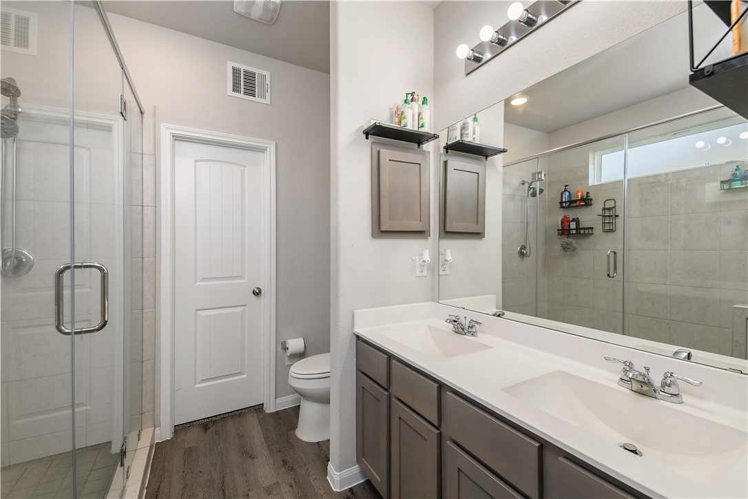 4705 Milagro Loop Bryan, TX 77807 - Photo 22 of 28 a bathroom with a double vanity sink toilet and shower
