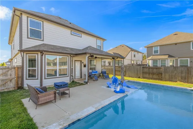 a view of pool with a lounge chair and floor to ceiling window