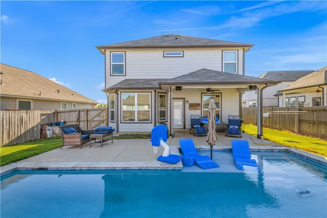 a swimming pool with outdoor seating and yard