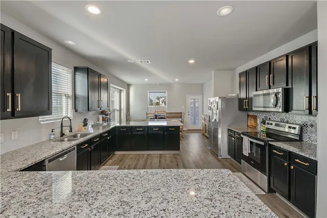 a large kitchen with lots of counter space a sink and appliances